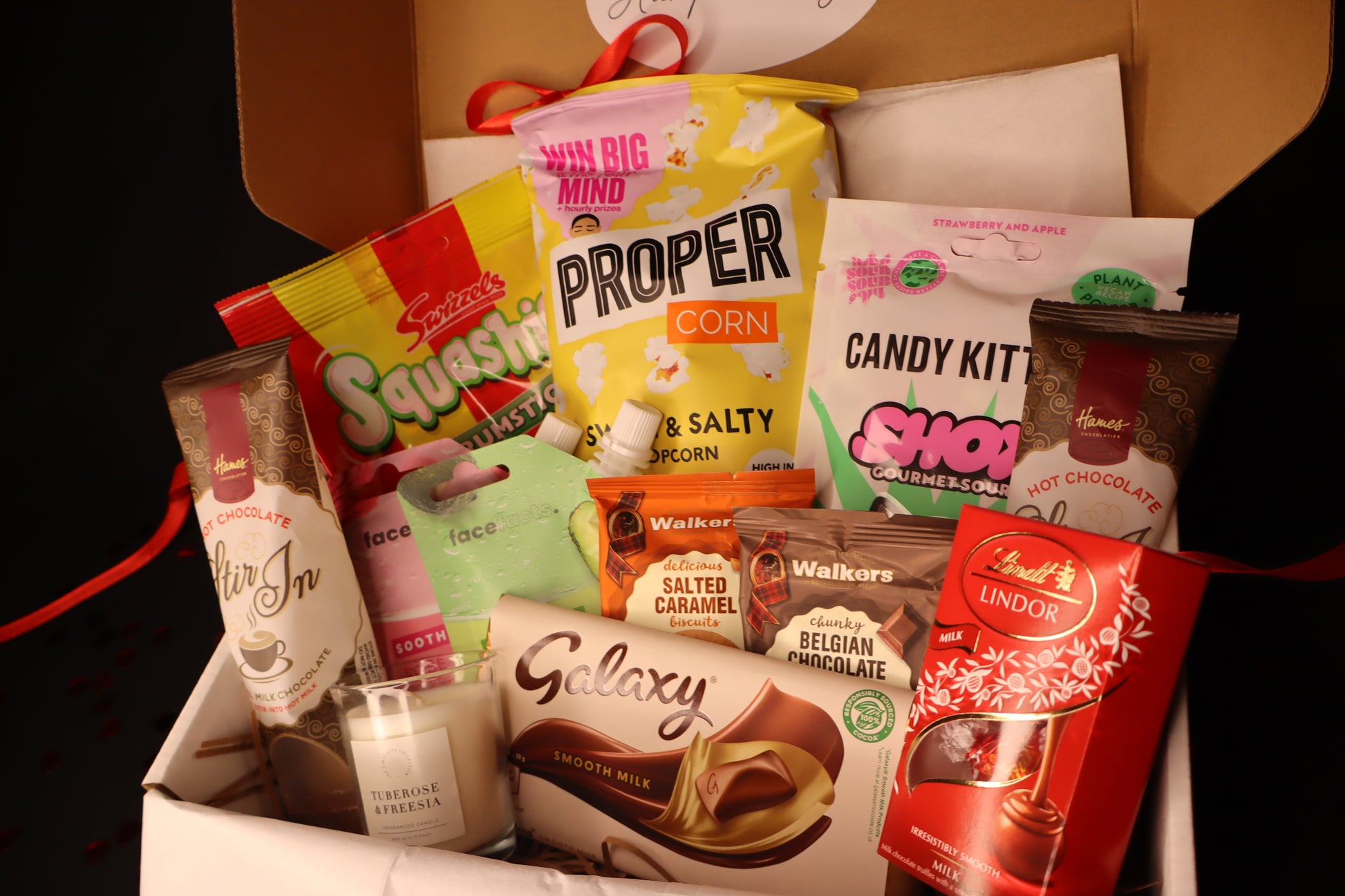 Assorted snacks and candies in a box with visible branding