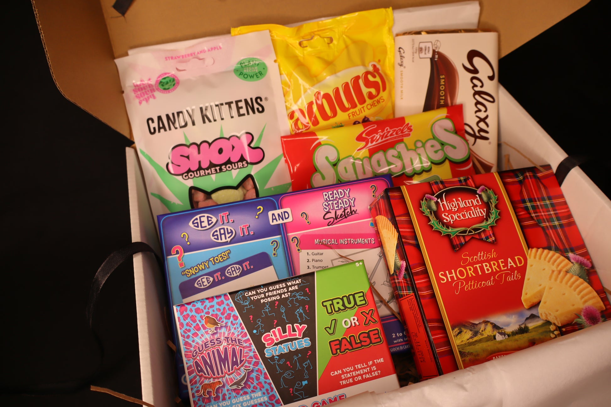 Assorted sweet treat packages including Galaxy and Candy Kittens in a box.