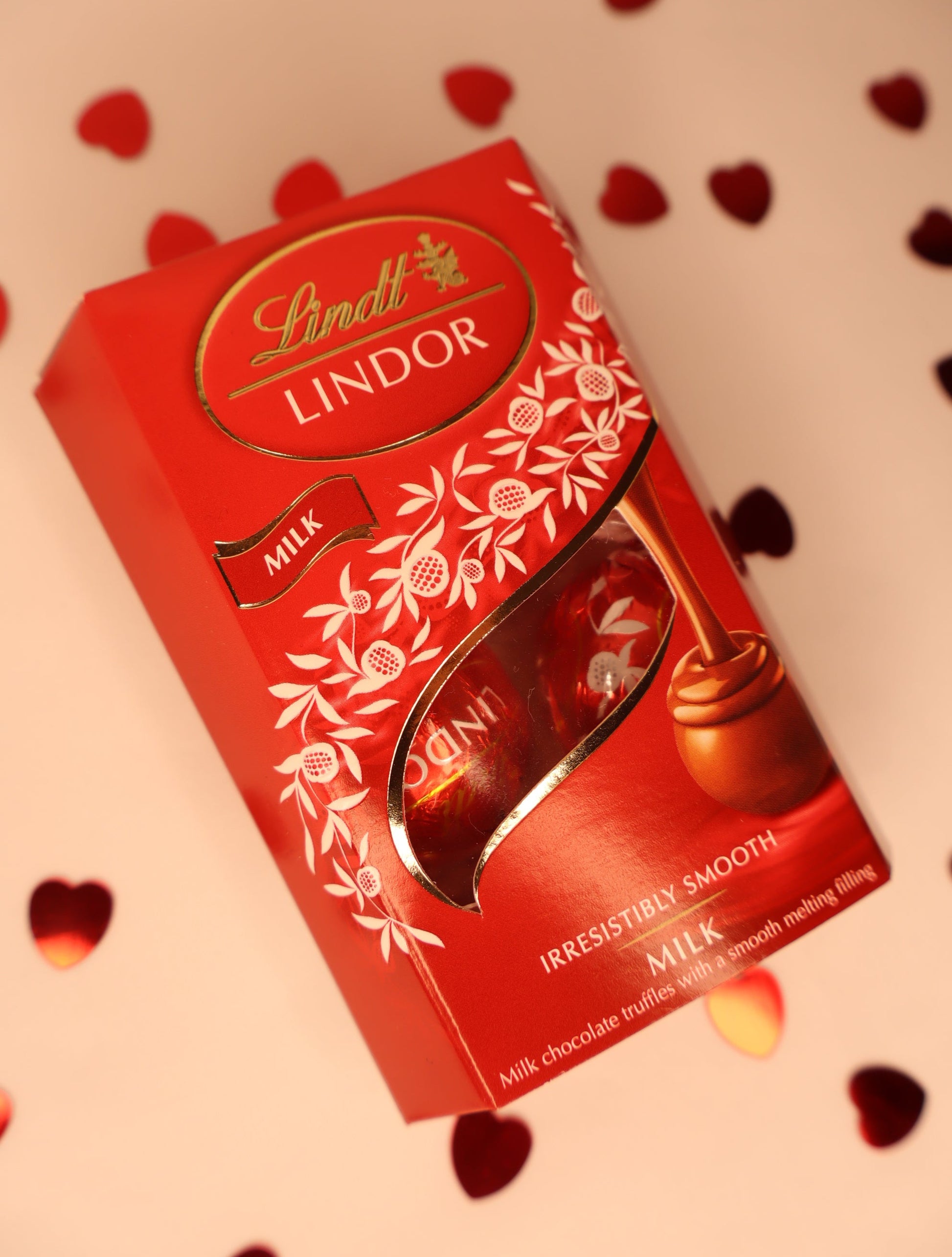 Lindt Lindor chocolate truffles packaging on a heart-patterned background