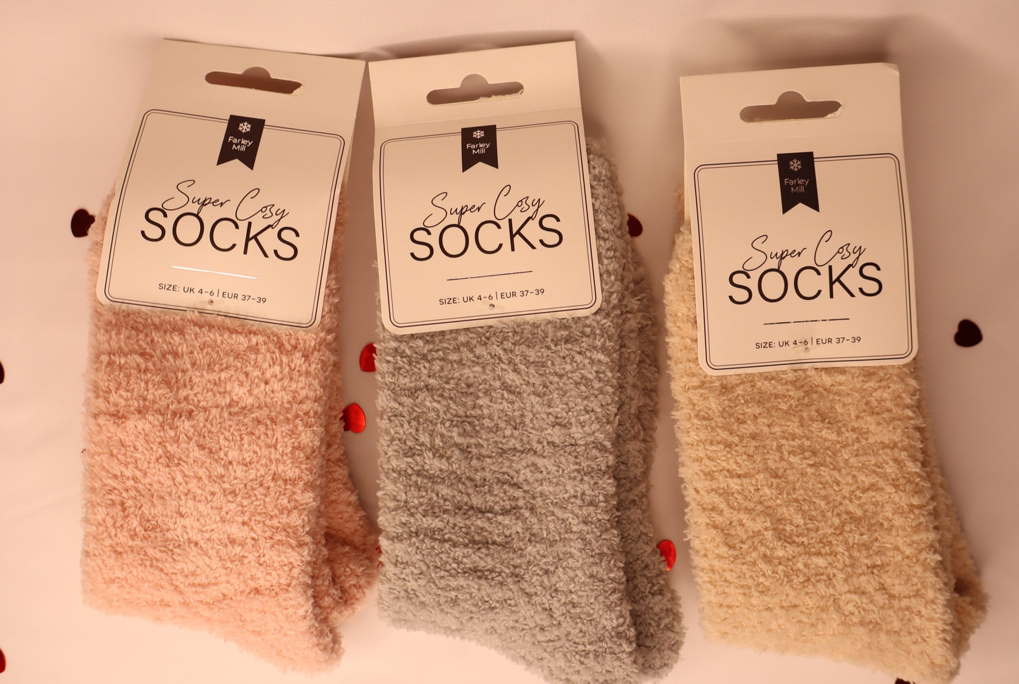 Three pairs of socks with packaging labels on a light background