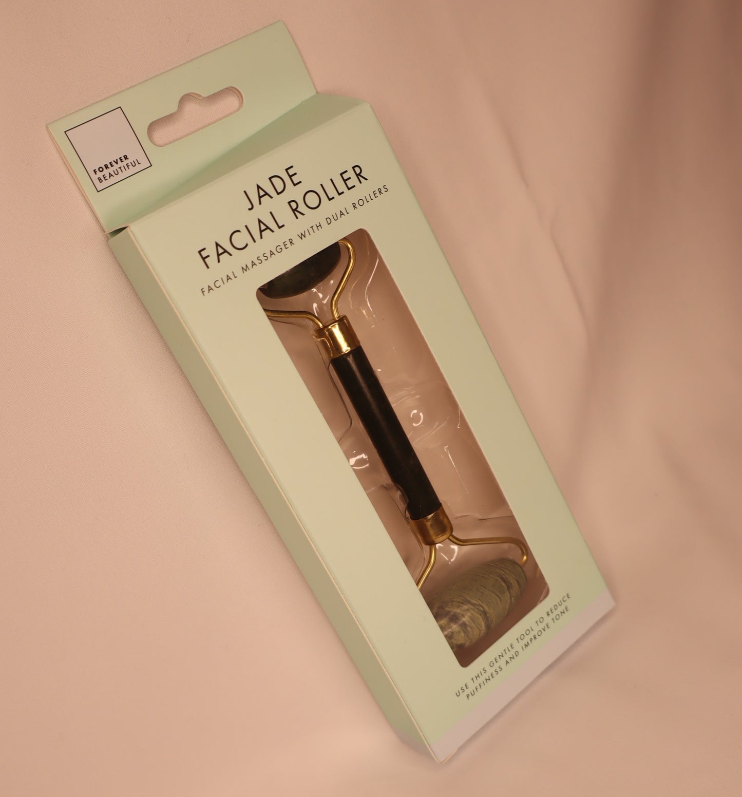 Jade facial roller in packaging on a white background