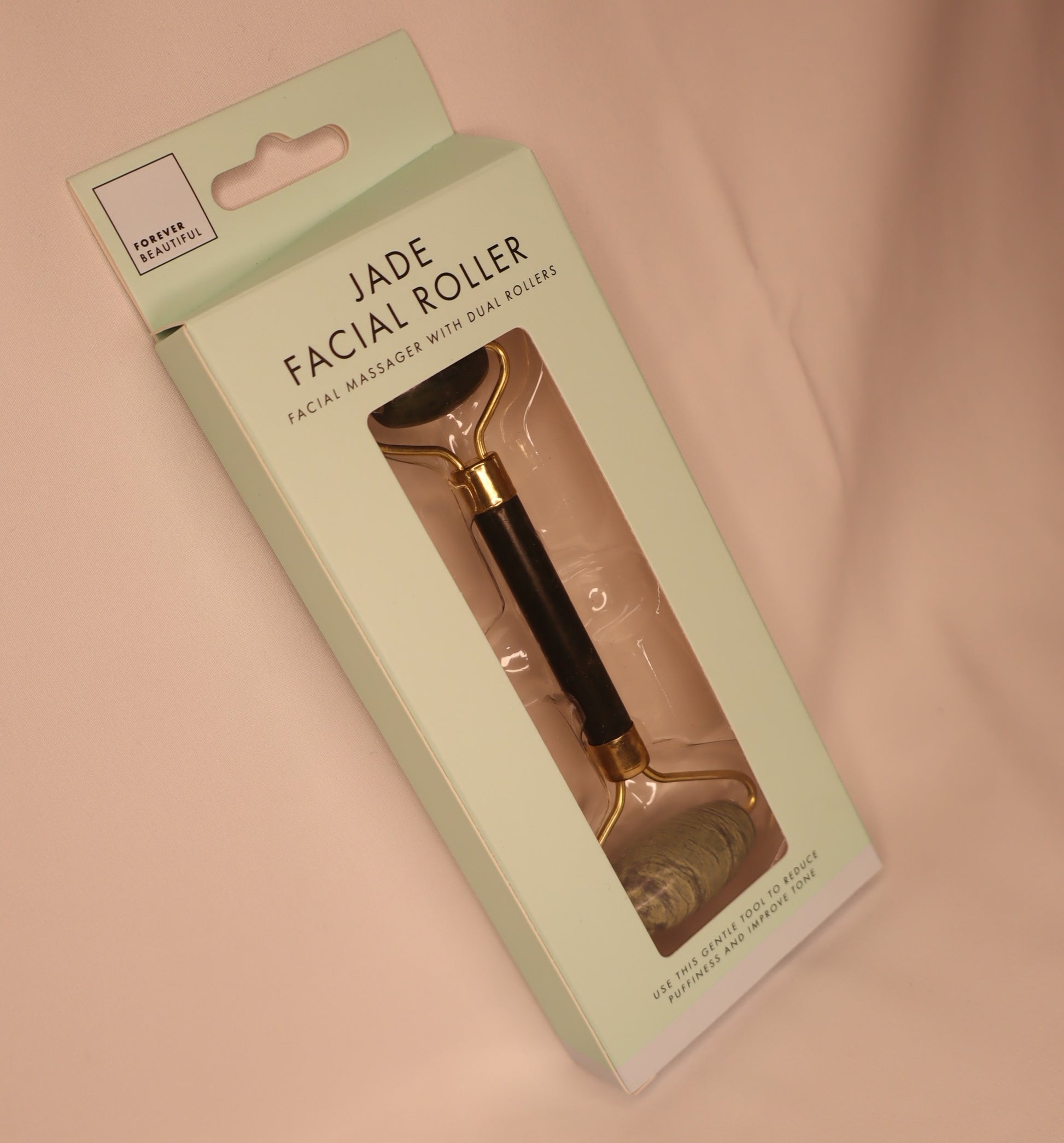Jade facial roller in packaging on a white background
