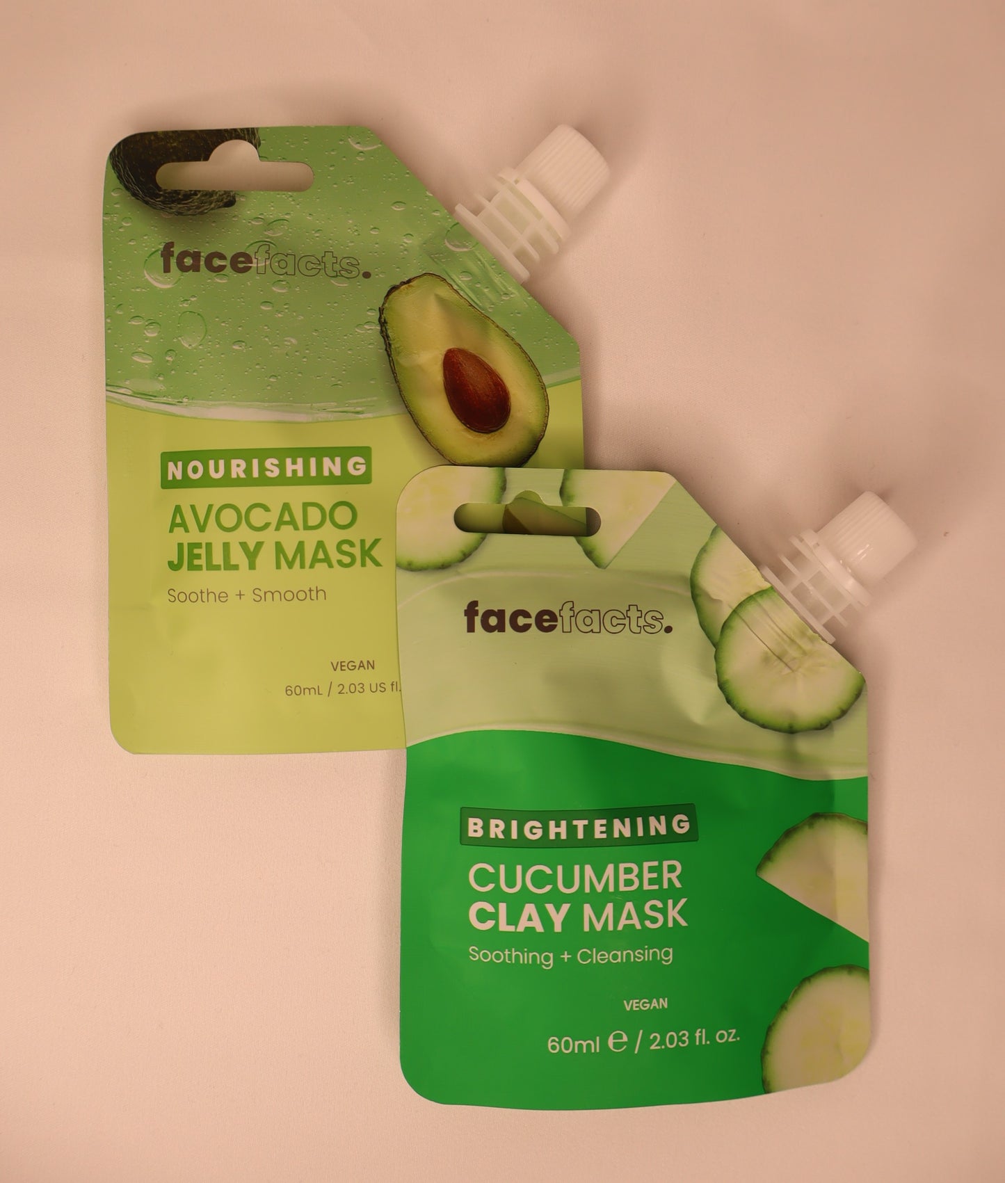 Two face mask packets, one avocado jelly mask and one cucumber clay mask, on a white background.