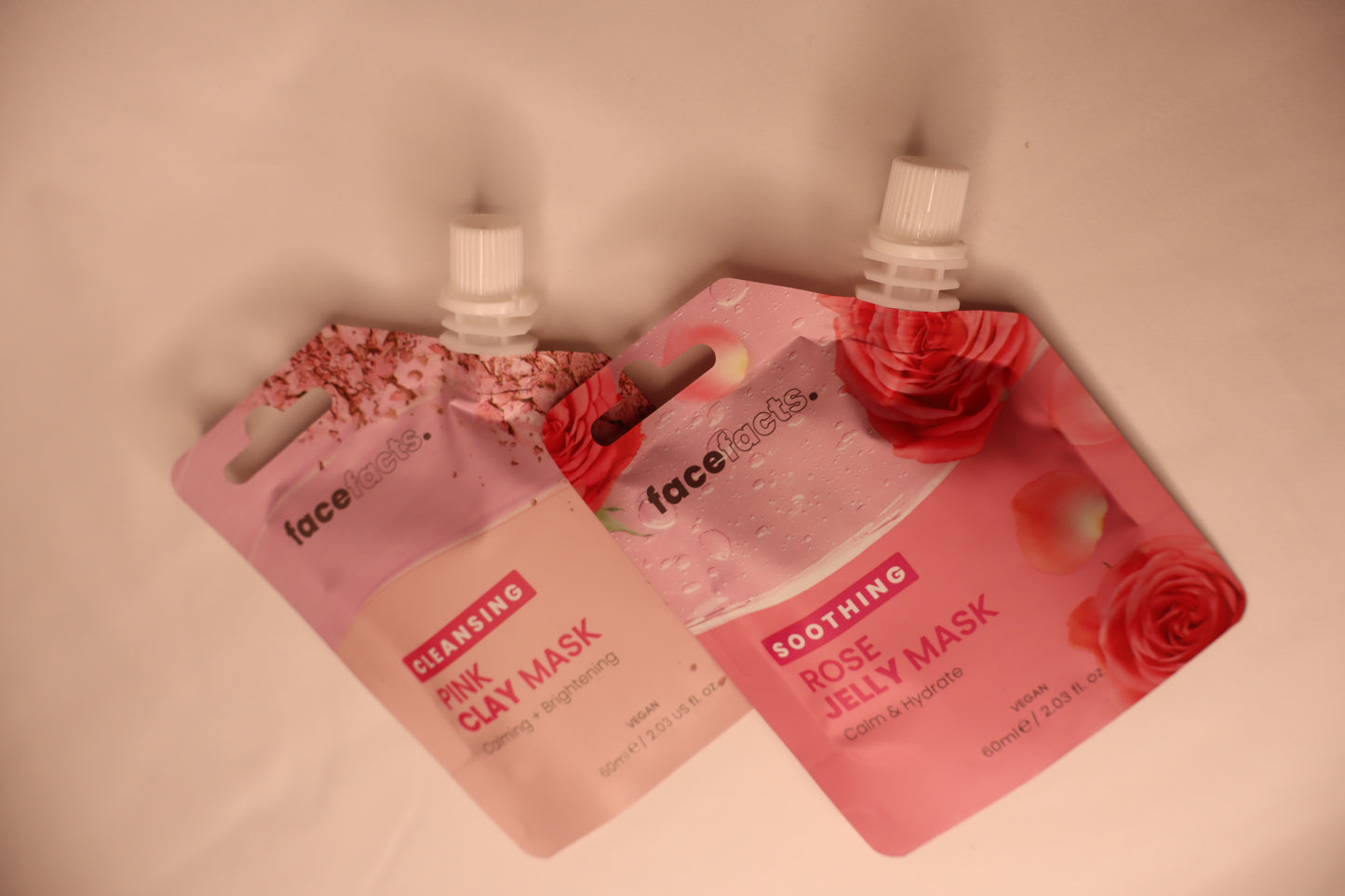 Two face mask packets, one labeled 'Pink Clay Mask' and the other 'Rose Jelly Mask', on a white background.